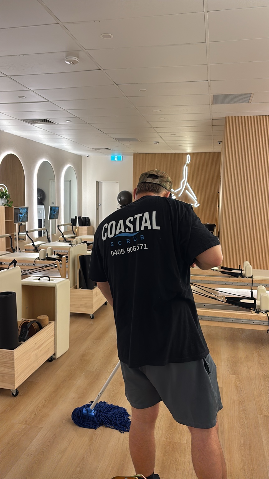 Coastal Scrub team member cleaning a Pilates studio